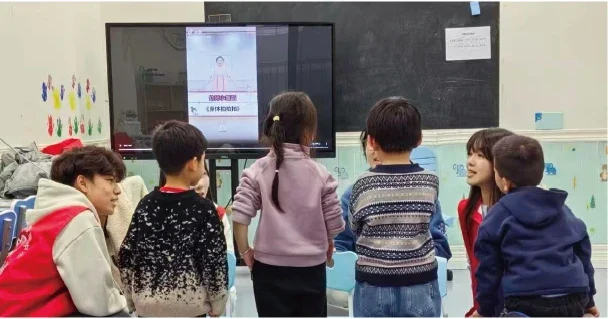 Students and children take part in a classroom group activity.