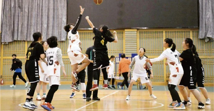 Players contest the ball during a basketball game.