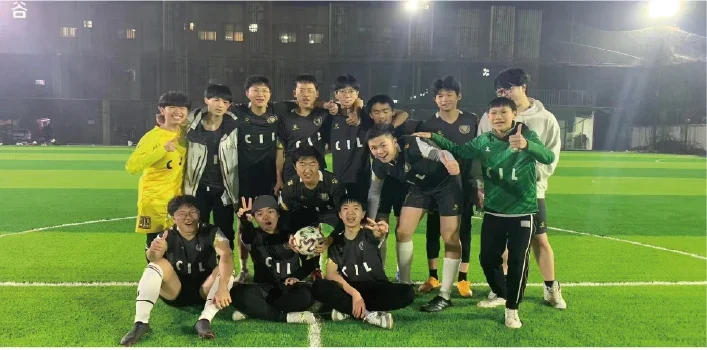 Football players pose together on the pitch.